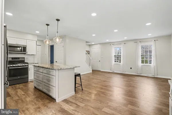a kitchen with granite countertop kitchen island cabinets and stainless steel appliances