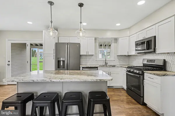 a kitchen with a refrigerator a stove a microwave and wooden floor
