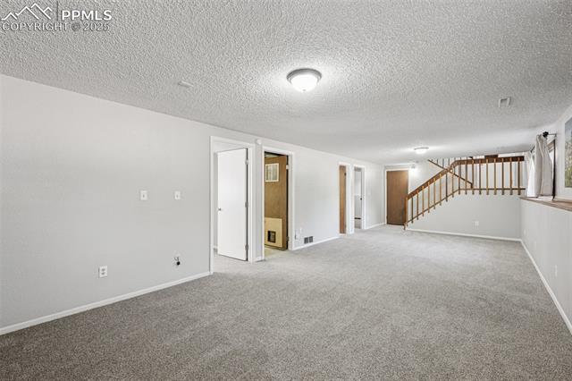 7233 River Bend Road Colorado Springs, CO 80911 - Photo 26 of 44 Lower level family room looking towards bedroom, bathroom and laundry room doors, new paint
