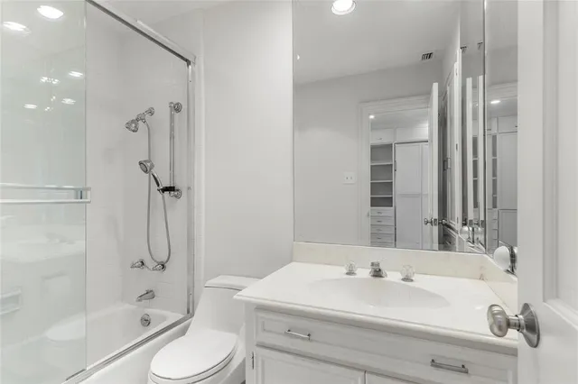 a bathroom with a granite countertop sink a toilet and a mirror