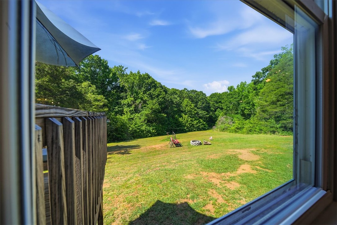 1014 Harris Road Anderson, SC 29625 - Photo 23 of 34 Green expanse framed by lush trees provides a serene backyard escape.