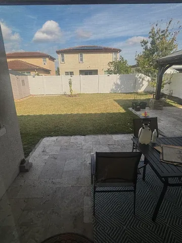 a view of a porch with furniture and floor to ceiling window