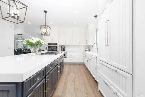 a kitchen with kitchen island a counter top space a sink stainless steel appliances and cabinets