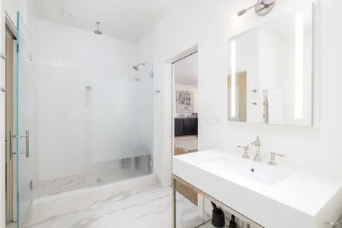 a bathroom with a sink a shower and a mirror