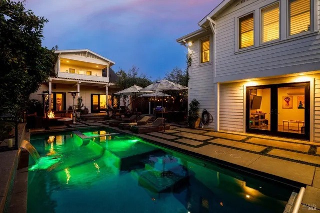 a view of a house with swimming pool and sitting area