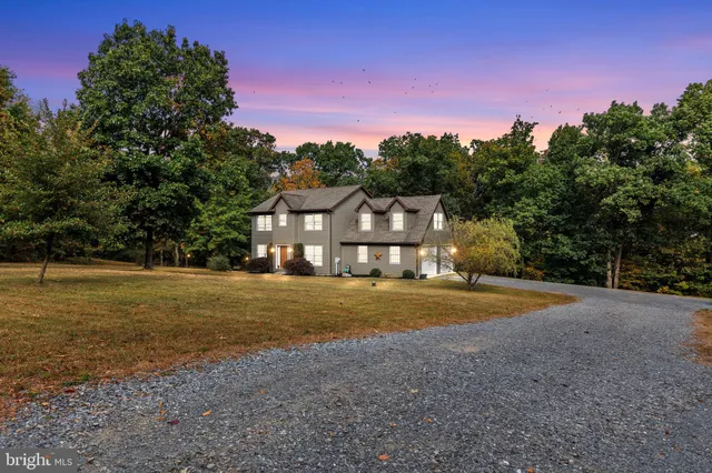 a front view of a house with a yard and trees
