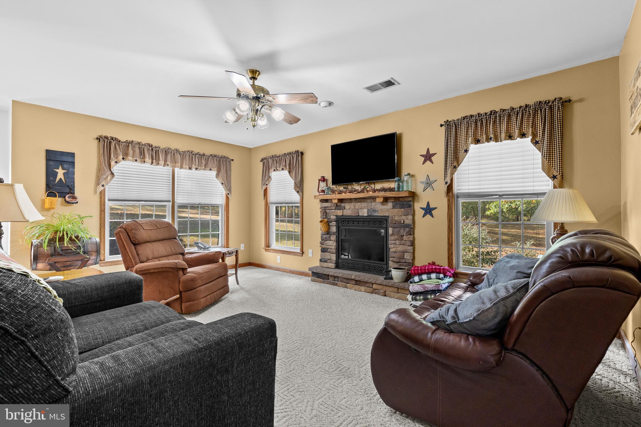 14731 Shimpstown Road Mercersburg, PA 17236 - Photo 18 of 52 a living room with furniture a fireplace and a flat screen tv