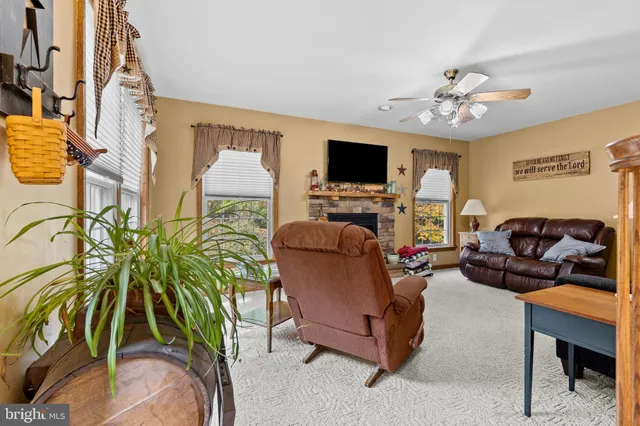 a living room with furniture a ceiling fan and a window