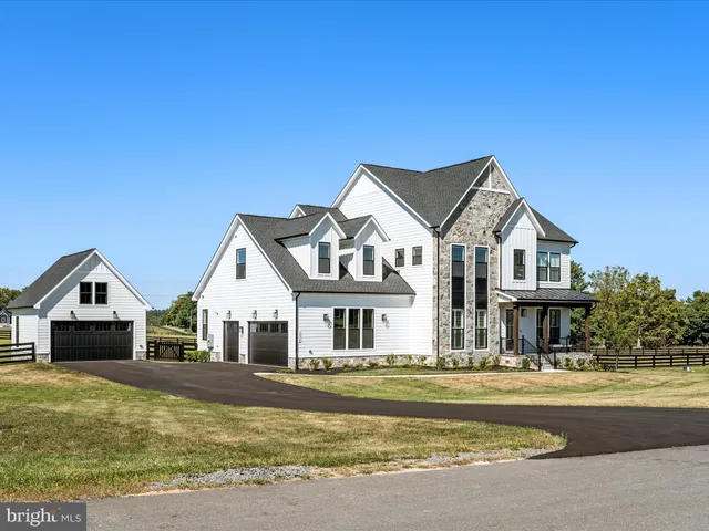 a front view of a house with a yard outdoor seating and garage