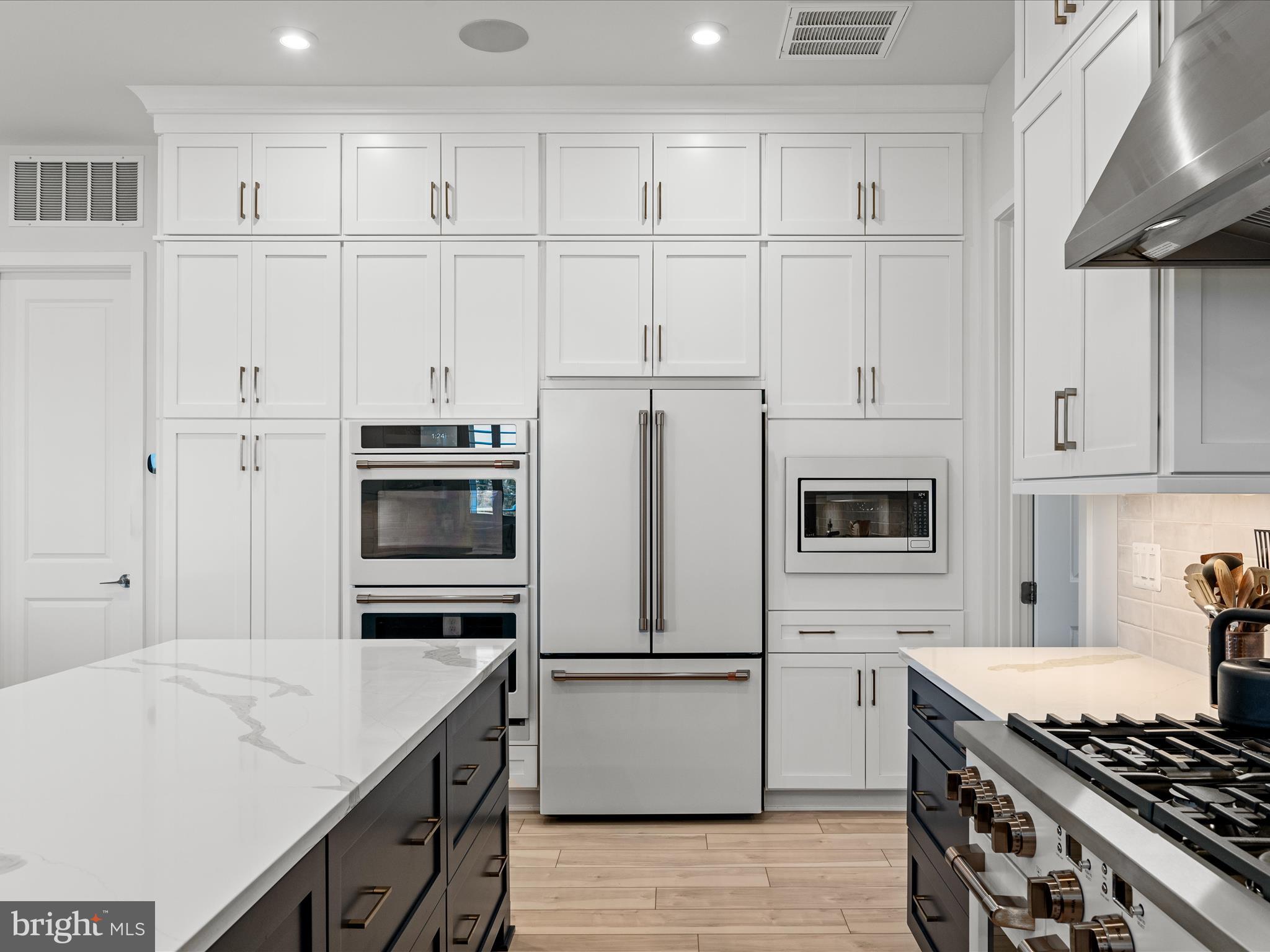 38906 Rumely Way Waterford, VA 20197 - Photo 32 of 99 a kitchen with white cabinets and white appliances