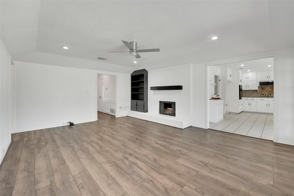 2316 Westpark Way Circle Euless, TX 76040 - Photo 1 of 1 Unfurnished living room featuring ceiling fan, visible vents, recessed lighting, a brick fireplace, and light wood finished floors