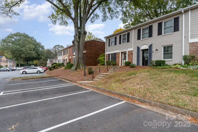 a view of a white house with a large tree