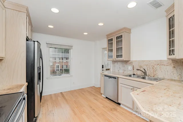 a kitchen with stainless steel appliances granite countertop a sink stove and refrigerator