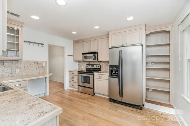 a kitchen with granite countertop a refrigerator and a sink