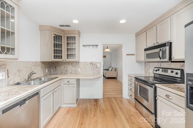 a kitchen with stainless steel appliances a sink dishwasher stove refrigerator and microwave