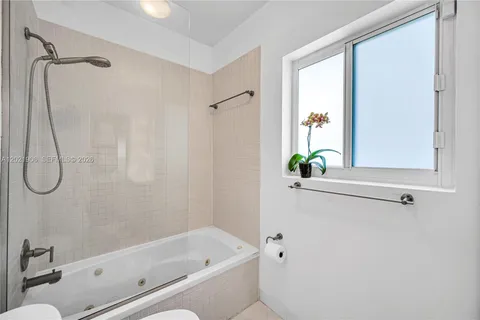 a bathroom with a bath tub with a shower