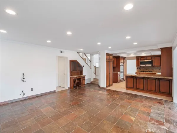 a view of a kitchen with kitchen island and stainless steel appliances