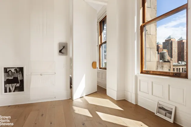 a view of a bedroom with wooden floor and windows