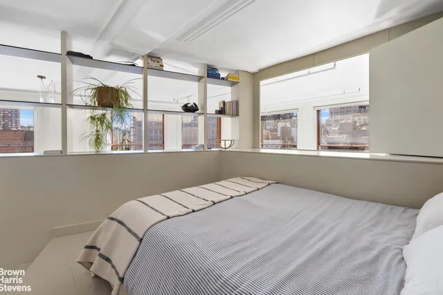 a bedroom with a large bed and windows