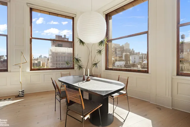 a dining room with furniture a painting and a potted plant