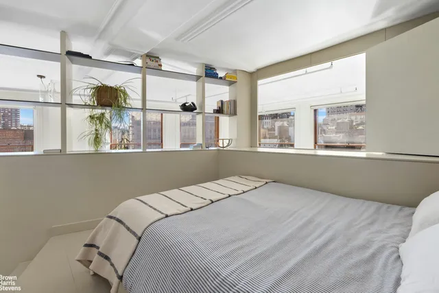 a view of a bedroom with a bed and wooden floor