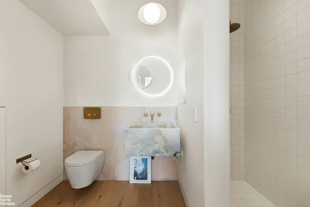 a bathroom with a toilet a sink and mirror