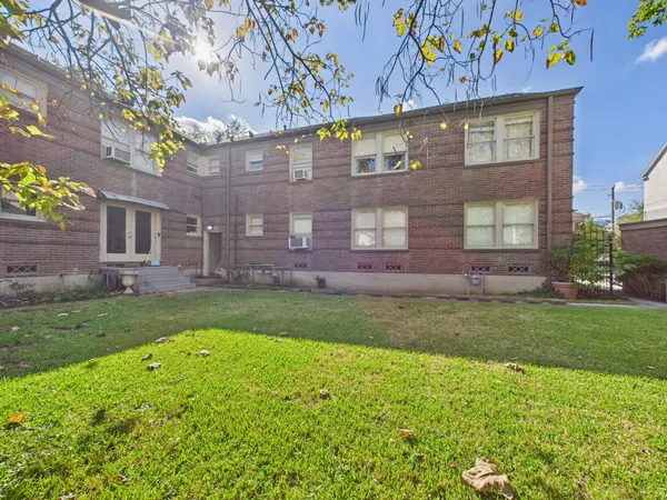 a view of a brick building next to a yard