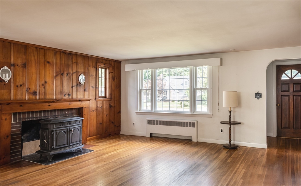 21 Ortins Road Hamilton, MA 01982 - Photo 6 of 16 an empty room with wooden floor and fireplace
