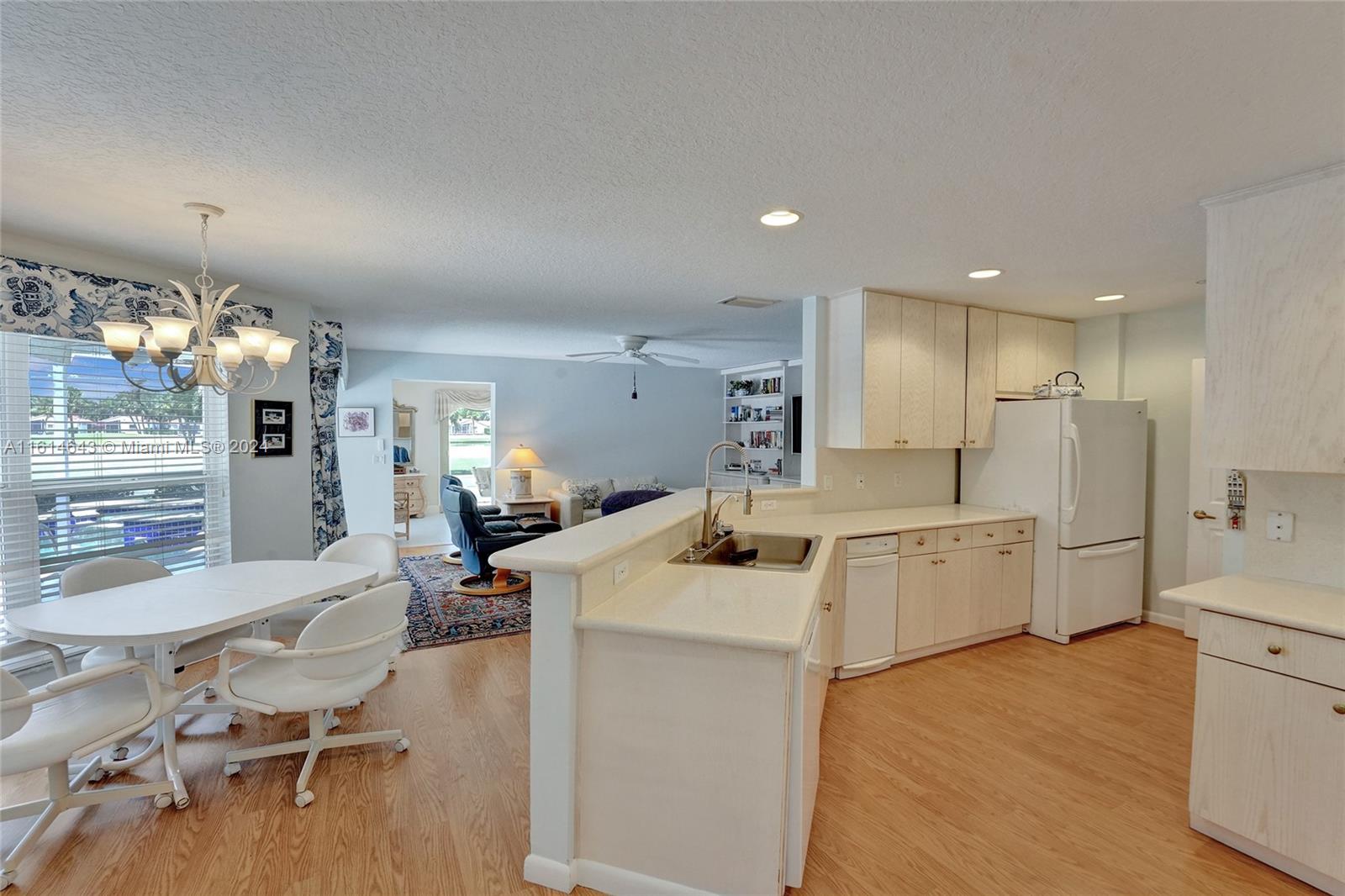17269 Balboa Point Way Boca Raton, FL 33487 - Photo 14 of 41 a large white kitchen with stainless steel appliances kitchen island granite countertop a sink and cabinets