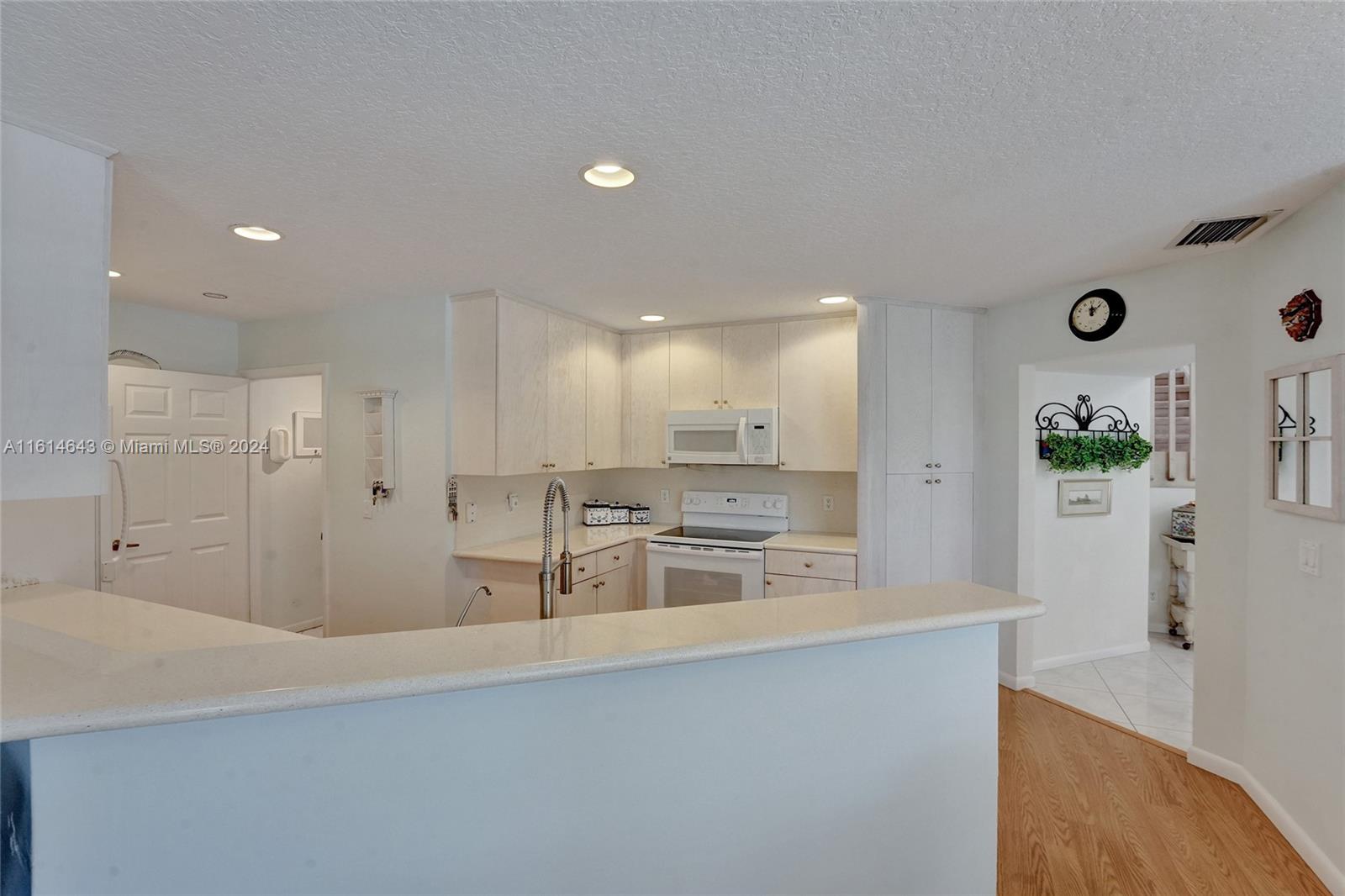17269 Balboa Point Way Boca Raton, FL 33487 - Photo 19 of 41 a view of a kitchen with kitchen island a sink wooden floor and stainless steel appliances