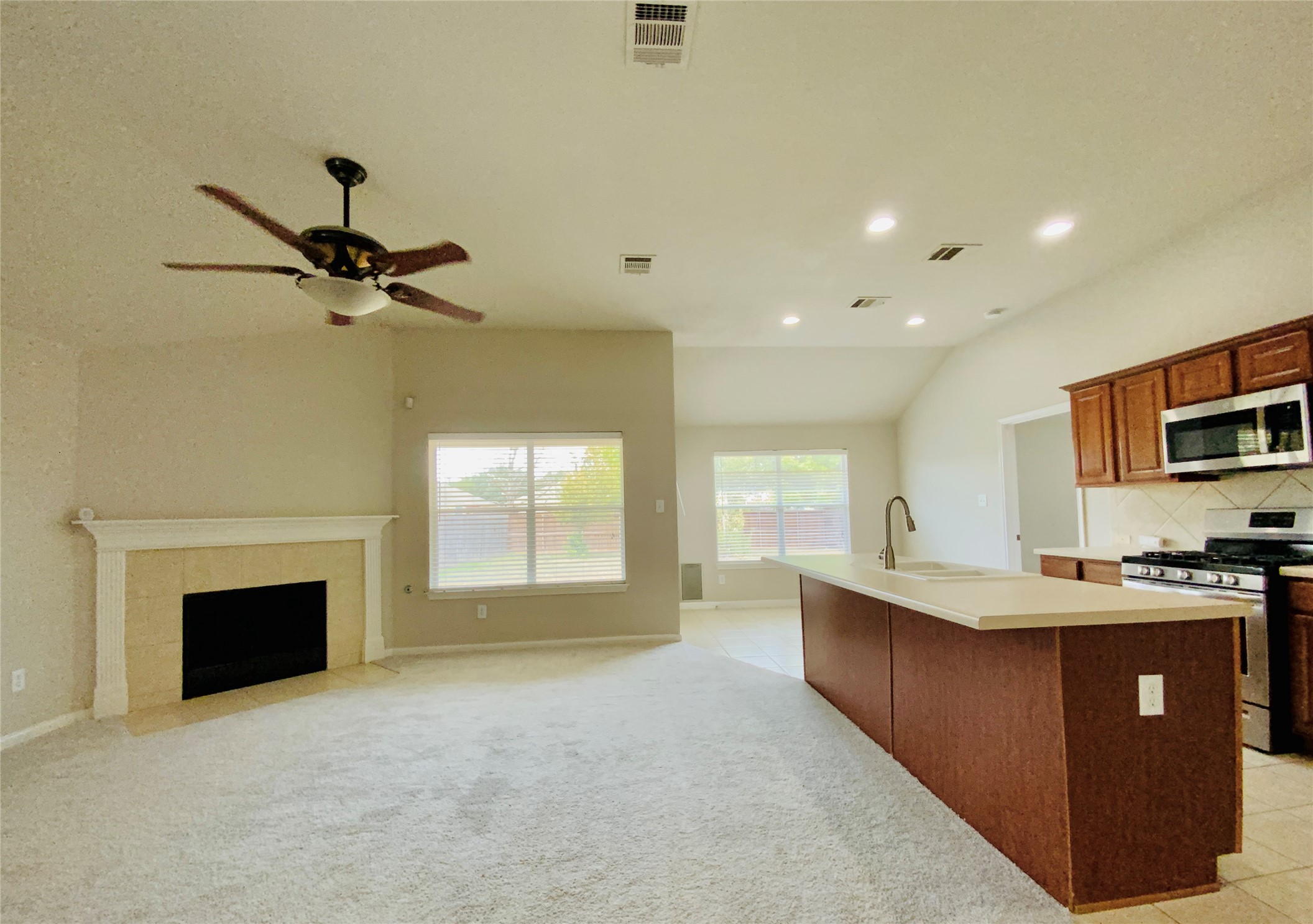 18704 Silent Water Way Pflugerville, TX 78660 - Photo 14 of 14 a view of a kitchen with a sink a fireplace and windows