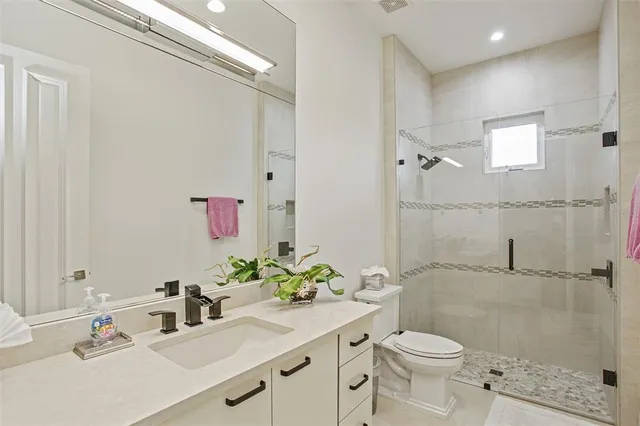 a bathroom with a sink a toilet and shower