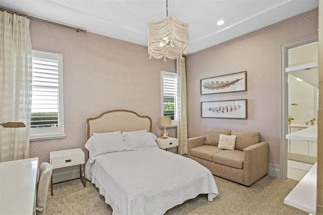 a bedroom with a bed a chair and the chandelier