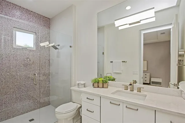 a bathroom with a granite countertop sink toilet and shower