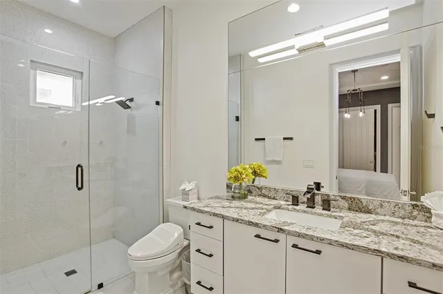 a bathroom with a sink a toilet and shower