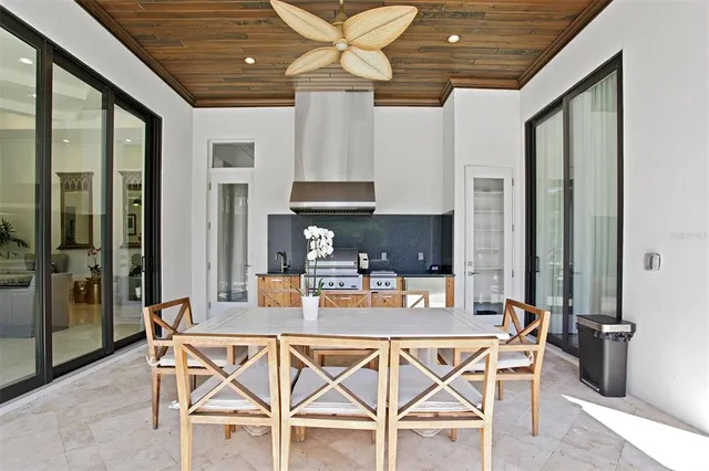a dining room with furniture a chandelier and glass door