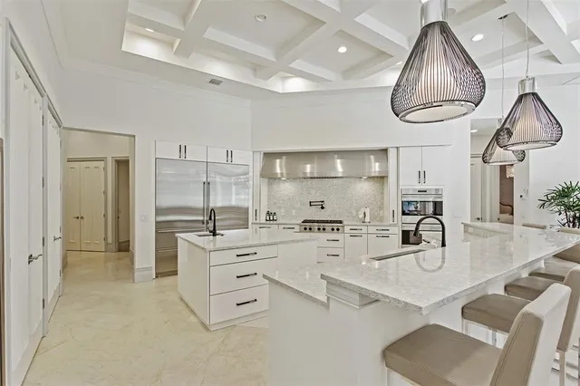 a kitchen with stainless steel appliances kitchen island granite countertop a stove a sink and a refrigerator