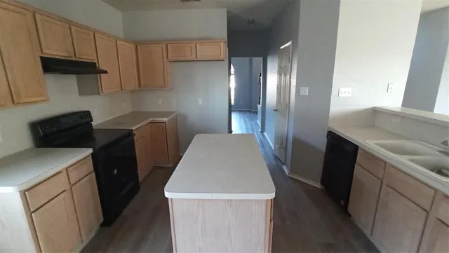 a kitchen with granite countertop a refrigerator a stove a sink a washer and dryer