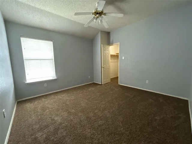 an empty room with windows and fan