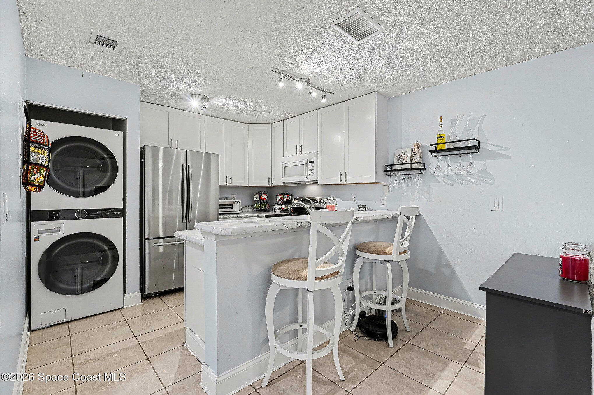 1491 Sheafe Avenue Northeast, Unit 104 Palm Bay, FL 32905 - Photo 4 of 19 a kitchen with a refrigerator and a stove top oven