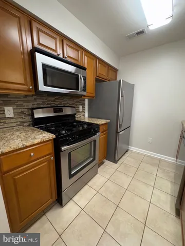 a kitchen with stainless steel appliances granite countertop a stove microwave and refrigerator