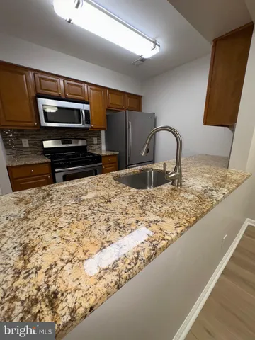 a kitchen with kitchen island granite countertop a stove a sink and a granite counter top