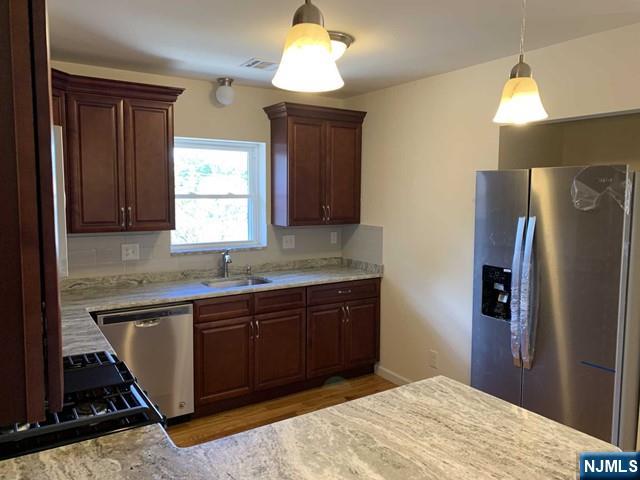 a kitchen with stainless steel appliances granite countertop a refrigerator and a sink