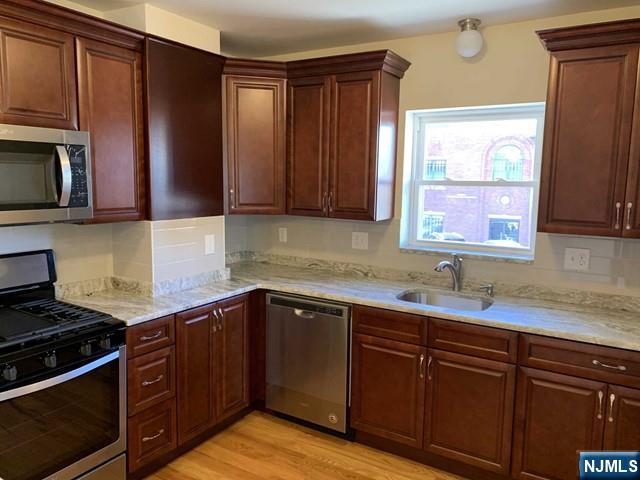 145 Kinderkamack Road Park Ridge, NJ 07656 - Photo 2 of 15 a kitchen with stainless steel appliances granite countertop wooden cabinets and a stove top oven