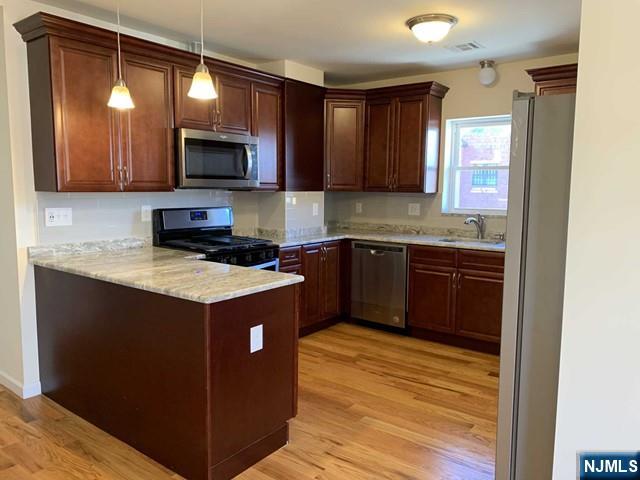 145 Kinderkamack Road Park Ridge, NJ 07656 - Photo 4 of 15 a kitchen with stainless steel appliances granite countertop a stove a sink and a microwave