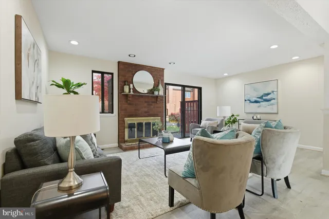 a living room with furniture kitchen view and a large window