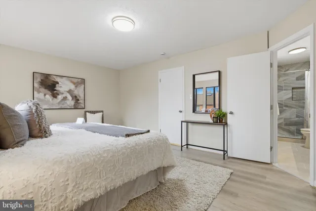 a bedroom with a bed and painting on the wall