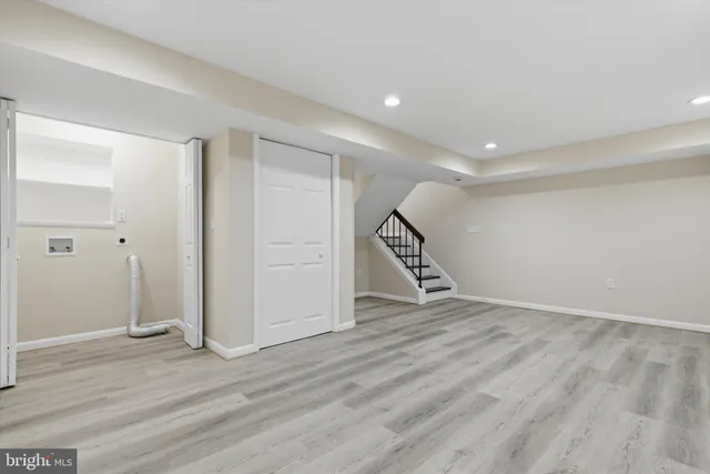 an empty room with wooden floor and staircase