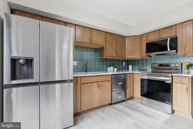 a kitchen with stainless steel appliances granite countertop a refrigerator sink and stove