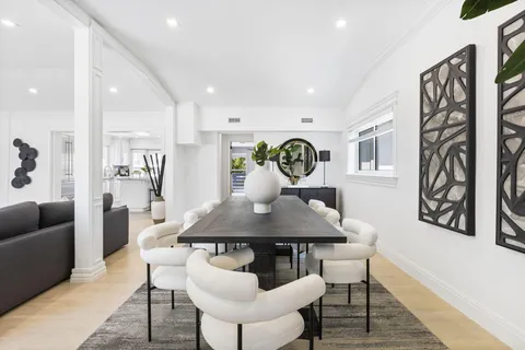 a kitchen with stainless steel appliances granite countertop a refrigerator a sink dishwasher a stove and white cabinets with wooden floor